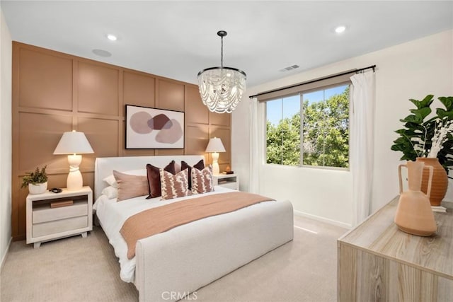 bedroom featuring light carpet and an inviting chandelier