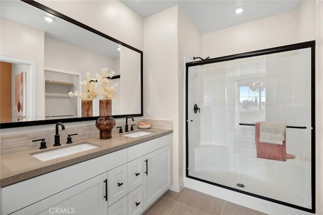 bathroom with tile patterned floors, vanity, an enclosed shower, and an inviting chandelier