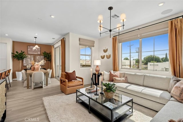 living room with light hardwood / wood-style floors and a chandelier