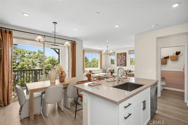 kitchen featuring pendant lighting, sink, white cabinetry, and stainless steel dishwasher