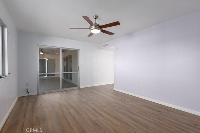 empty room with hardwood / wood-style flooring and ceiling fan