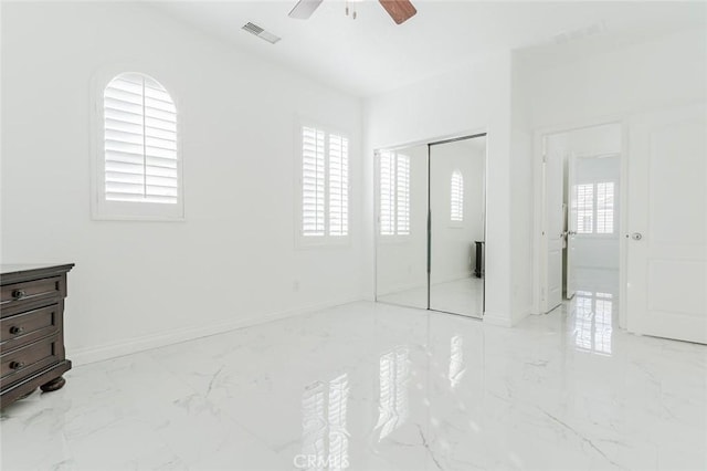 bedroom with ceiling fan, multiple windows, and a closet