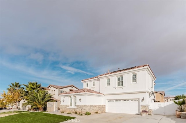 mediterranean / spanish-style home with a garage and a front lawn