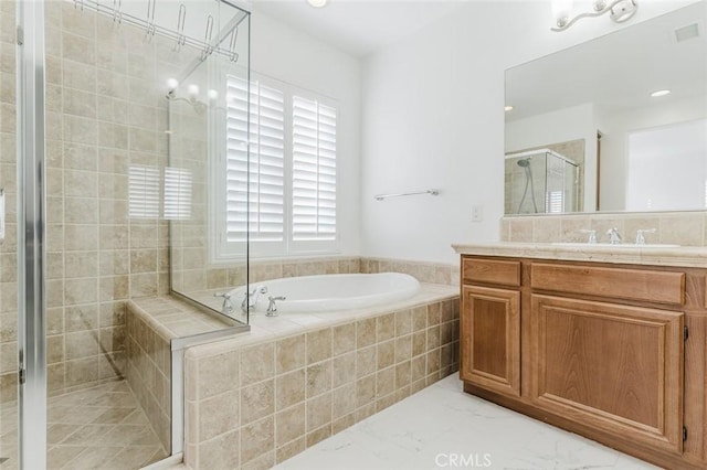 bathroom with vanity and shower with separate bathtub