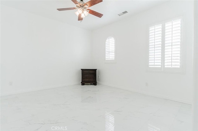 empty room with ceiling fan and a wealth of natural light