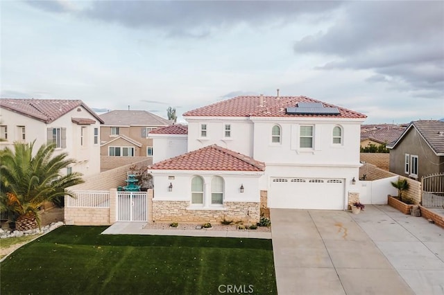 mediterranean / spanish house with solar panels, a garage, and a front yard