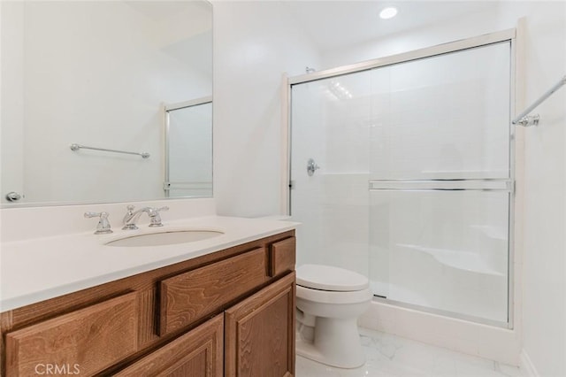 bathroom with a shower with door, vanity, and toilet