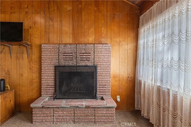 room details featuring wood walls, carpet floors, and a brick fireplace