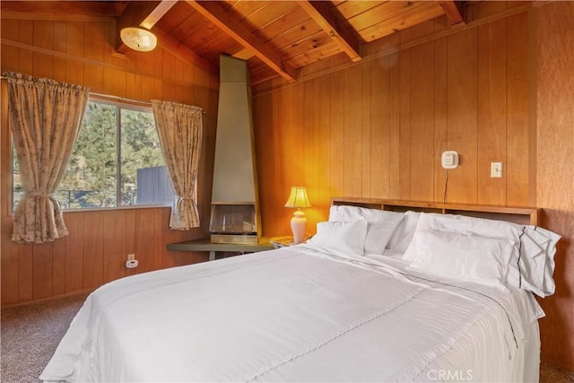 bedroom featuring lofted ceiling with beams, wood walls, carpet floors, and wood ceiling