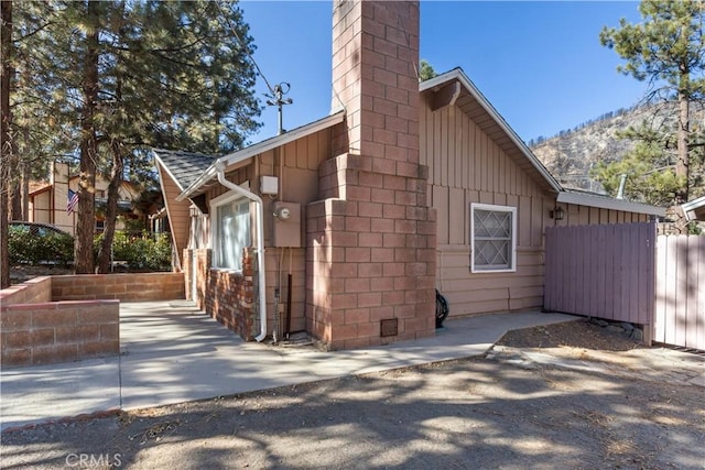 view of property exterior with a mountain view and a patio area