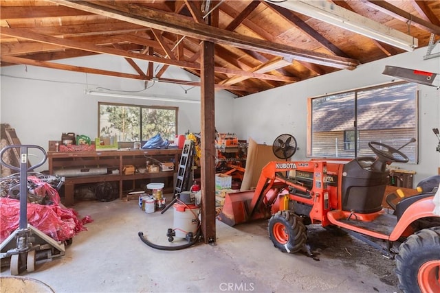 misc room featuring a workshop area, vaulted ceiling with beams, and concrete floors