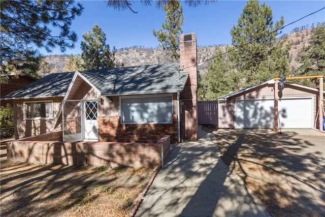 view of front of property featuring a mountain view, a garage, and an outdoor structure