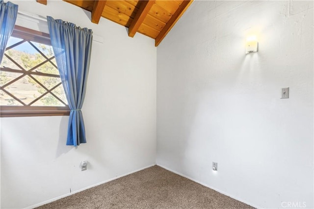 empty room featuring carpet, lofted ceiling with beams, and wooden ceiling