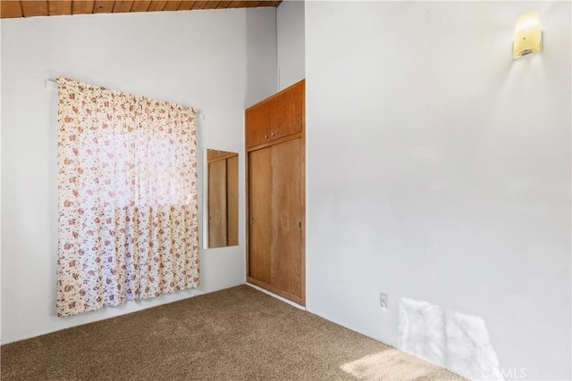 carpeted spare room with lofted ceiling and wood ceiling