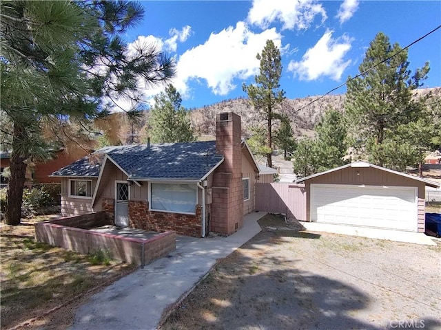 592 Mountain View Ave, Wrightwood, CA 92397 - view of front of house with a chimney, a detached garage, an outdoor structure, fence, and brick siding