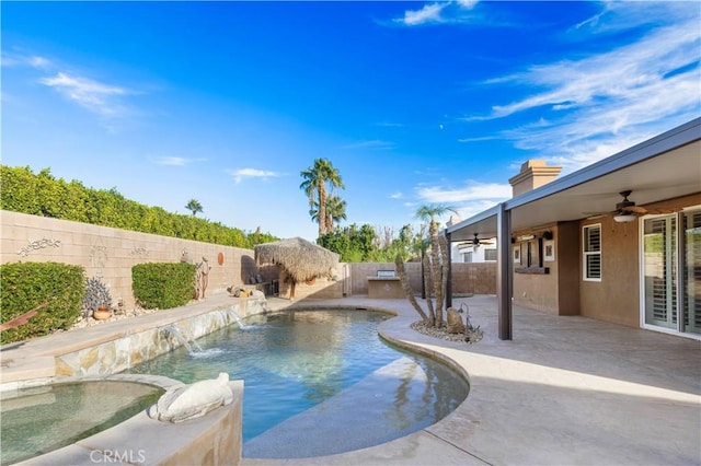 view of pool featuring a jacuzzi, pool water feature, a patio, and ceiling fan