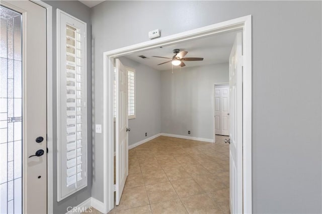 tiled entrance foyer featuring ceiling fan and a healthy amount of sunlight