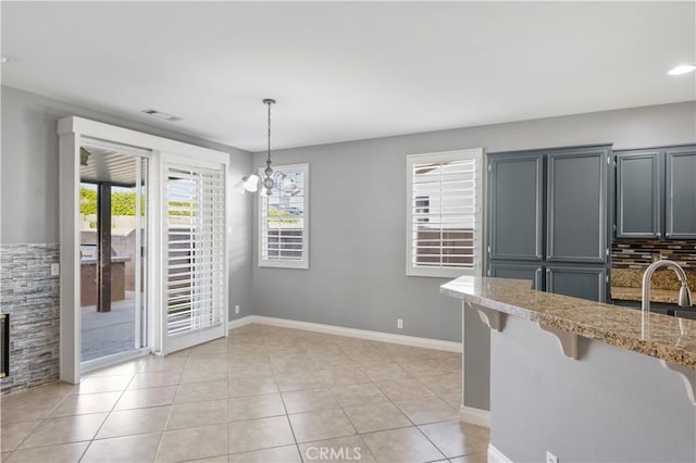 dining space with a notable chandelier, light tile patterned flooring, and a wealth of natural light