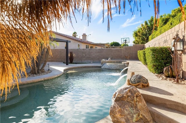 view of pool featuring pool water feature and an in ground hot tub