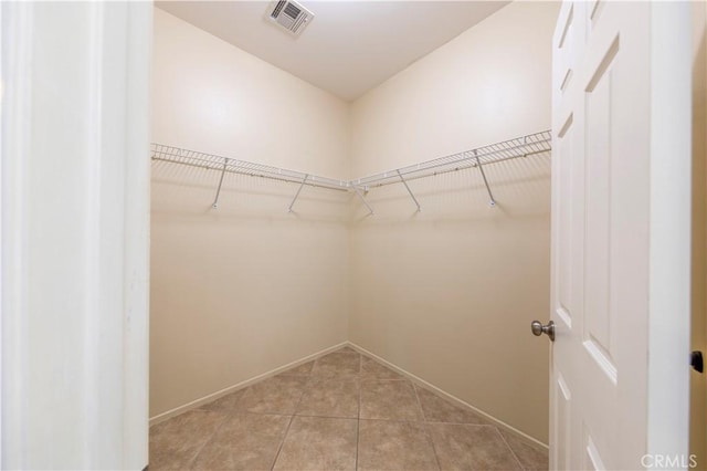 walk in closet with light tile patterned floors