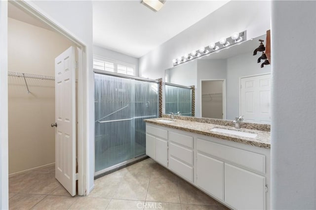 bathroom with tile patterned flooring, vanity, and a shower with shower door