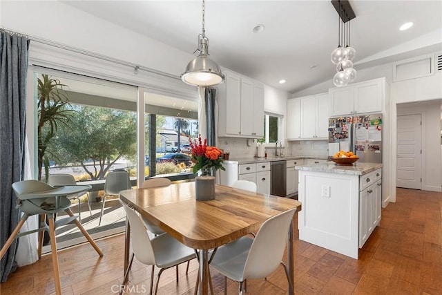 kitchen with pendant lighting, white cabinetry, lofted ceiling, and stainless steel appliances