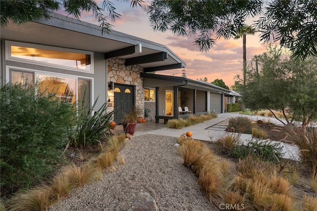 property exterior at dusk featuring a garage