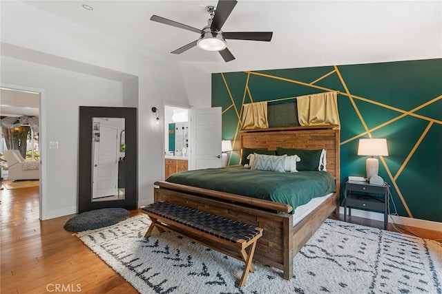 bedroom with wood-type flooring, connected bathroom, ceiling fan, and lofted ceiling