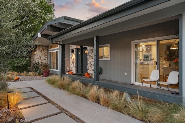 exterior entry at dusk featuring a porch