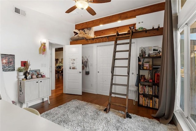 bedroom with beam ceiling, ceiling fan, and dark wood-type flooring