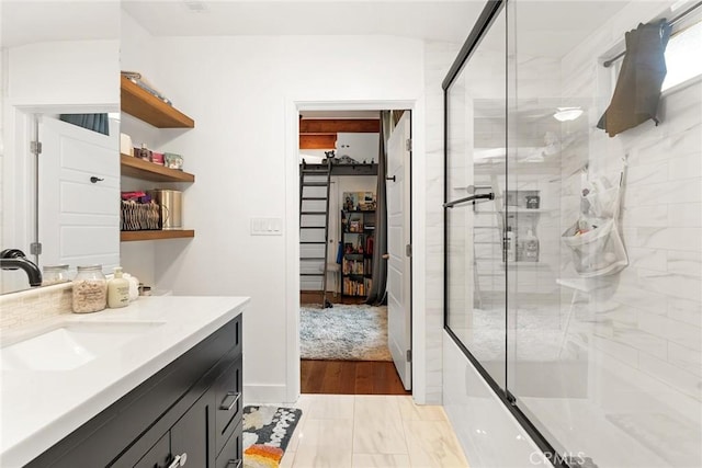 bathroom with shower / bath combination with glass door, hardwood / wood-style floors, and vanity