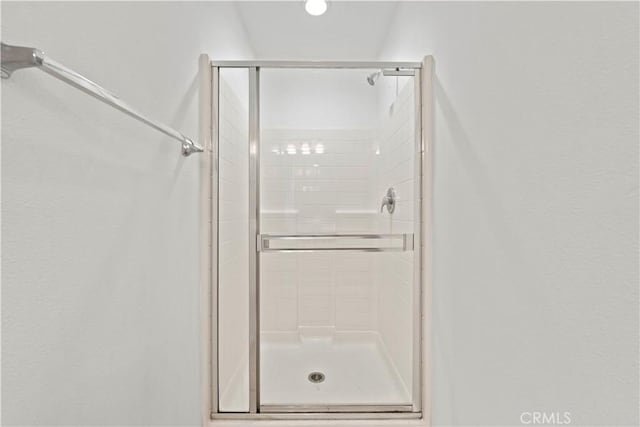 bathroom featuring a shower with door