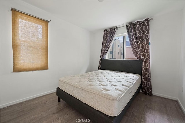 bedroom with dark wood-type flooring