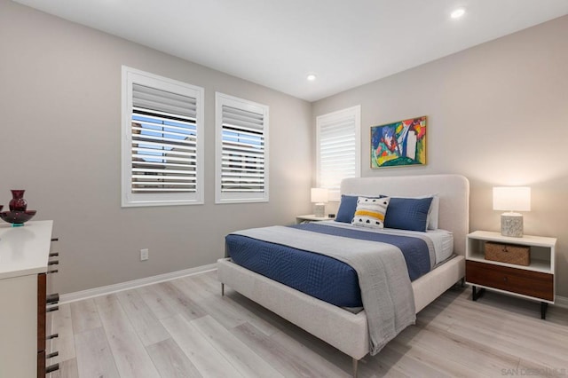 bedroom with light wood-type flooring and multiple windows