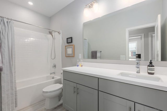 full bathroom featuring toilet, shower / bathtub combination with curtain, hardwood / wood-style flooring, and vanity