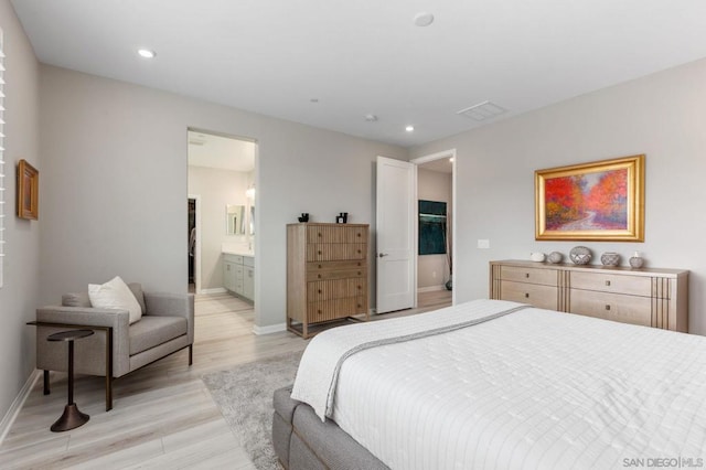 bedroom featuring ensuite bathroom and light hardwood / wood-style flooring