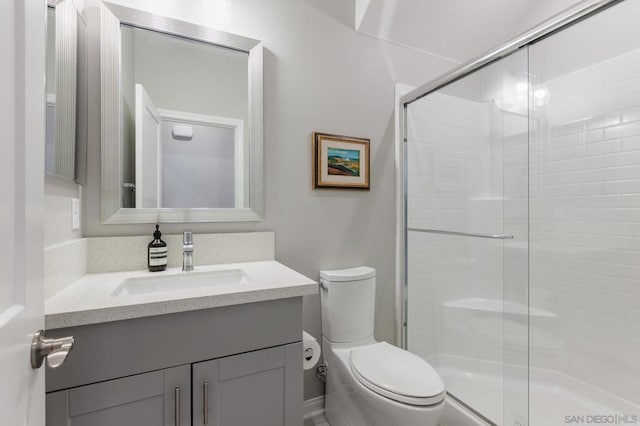 bathroom with toilet, vanity, and an enclosed shower