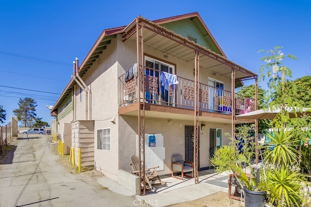 back of house featuring a balcony