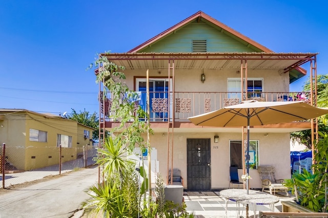 view of front of home with a patio area and a balcony