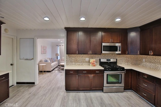 kitchen featuring tasteful backsplash, dark brown cabinets, stainless steel appliances, and light hardwood / wood-style flooring