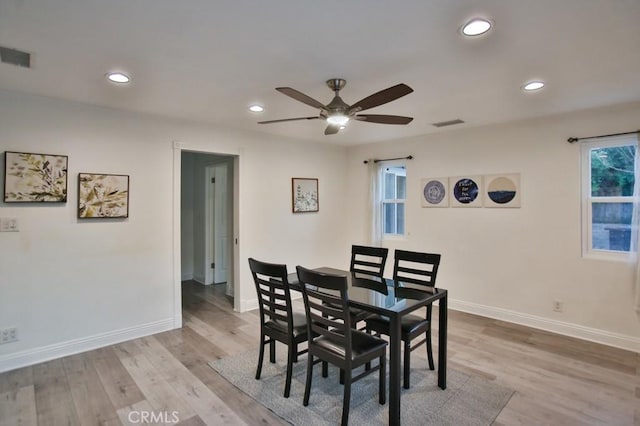 dining room featuring light wood-type flooring, ceiling fan, and a healthy amount of sunlight