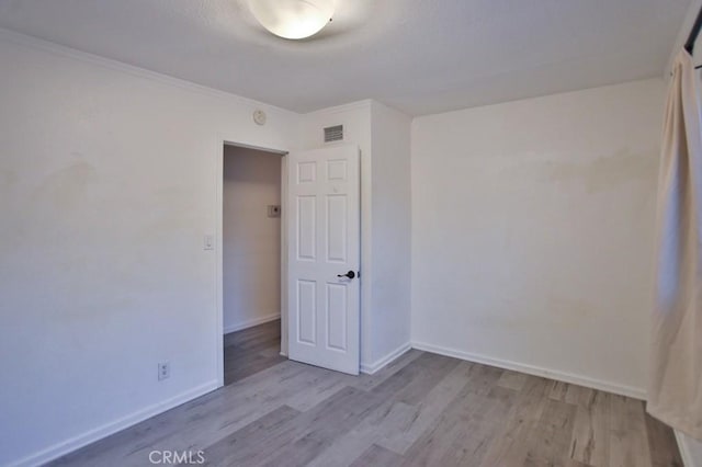 unfurnished room with ornamental molding and light hardwood / wood-style flooring