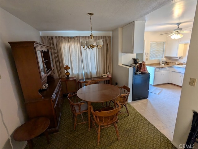 dining space with ceiling fan with notable chandelier