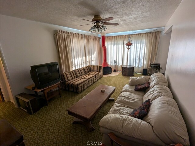 living room featuring ceiling fan, a textured ceiling, and carpet