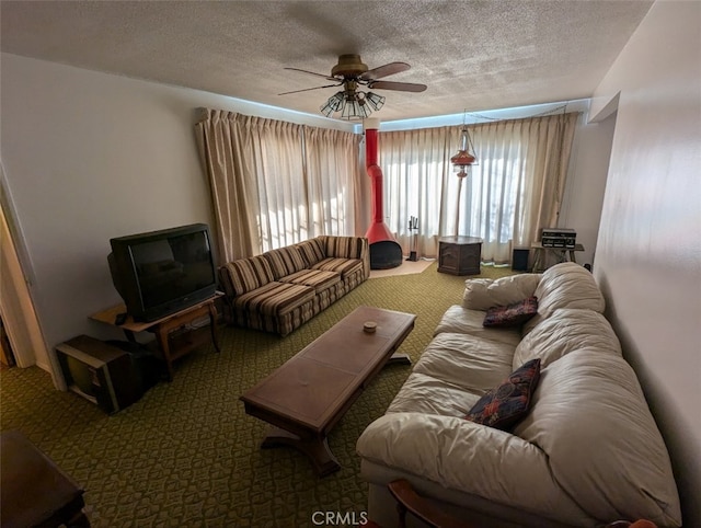 living room with ceiling fan, carpet flooring, and a textured ceiling