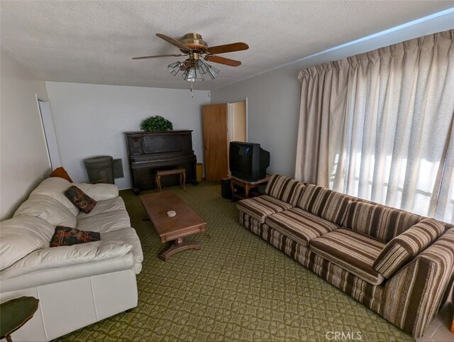 living room with ceiling fan and a textured ceiling