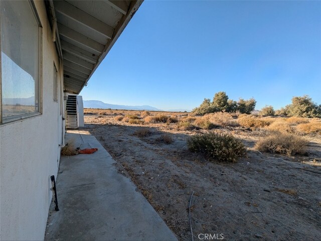 view of yard featuring central AC unit and a mountain view