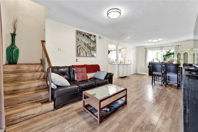 living room featuring light hardwood / wood-style floors and a textured ceiling