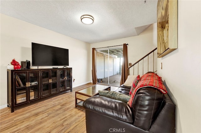 living room featuring a textured ceiling and light hardwood / wood-style flooring