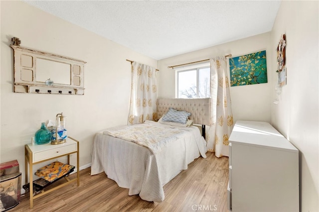 bedroom featuring a textured ceiling and light wood-type flooring